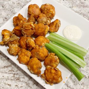 Buffalo Cauliflower Bites with celery and ranch dressing